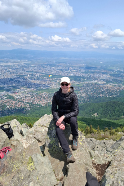 Lorena sitzt auf einem Berg, im Hintergrund die Stadt Sofia