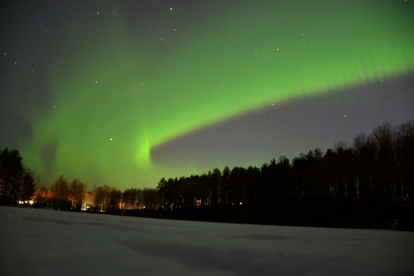 Nordlichter leuchten grün über einem zugefrorenen See